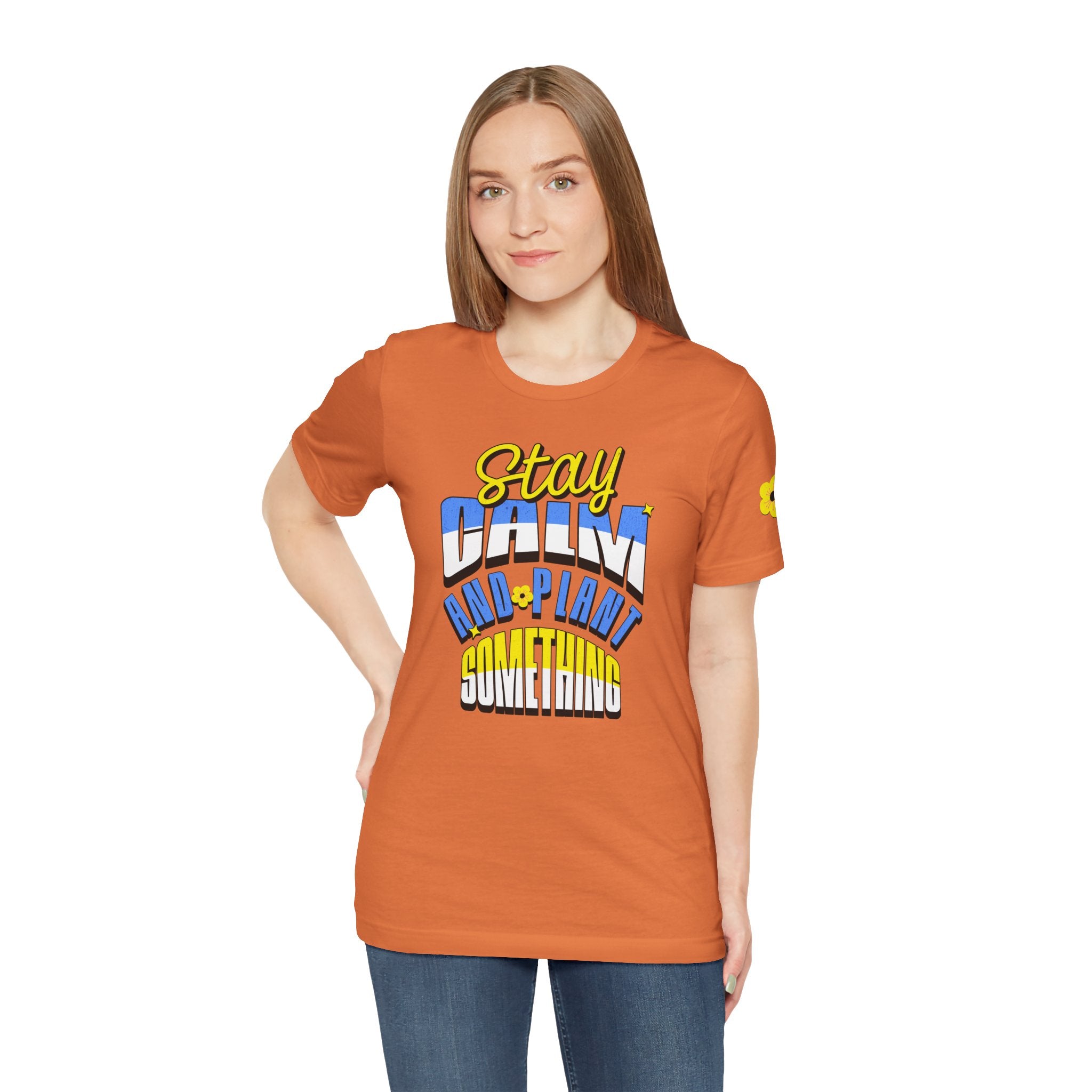 Person wearing an orange t-shirt with colorful text design on a white background