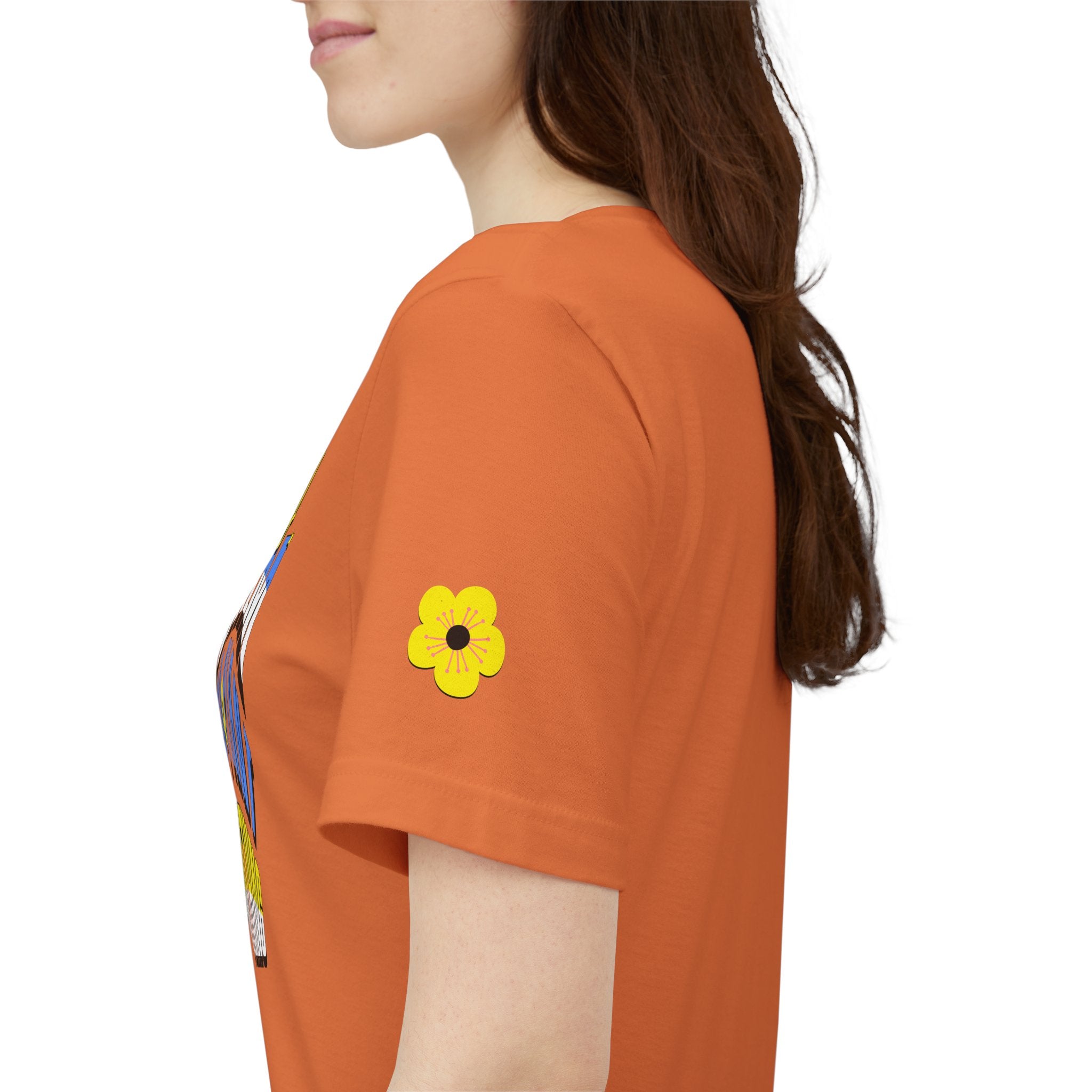 Person wearing an orange t-shirt with a yellow flower design on a white background