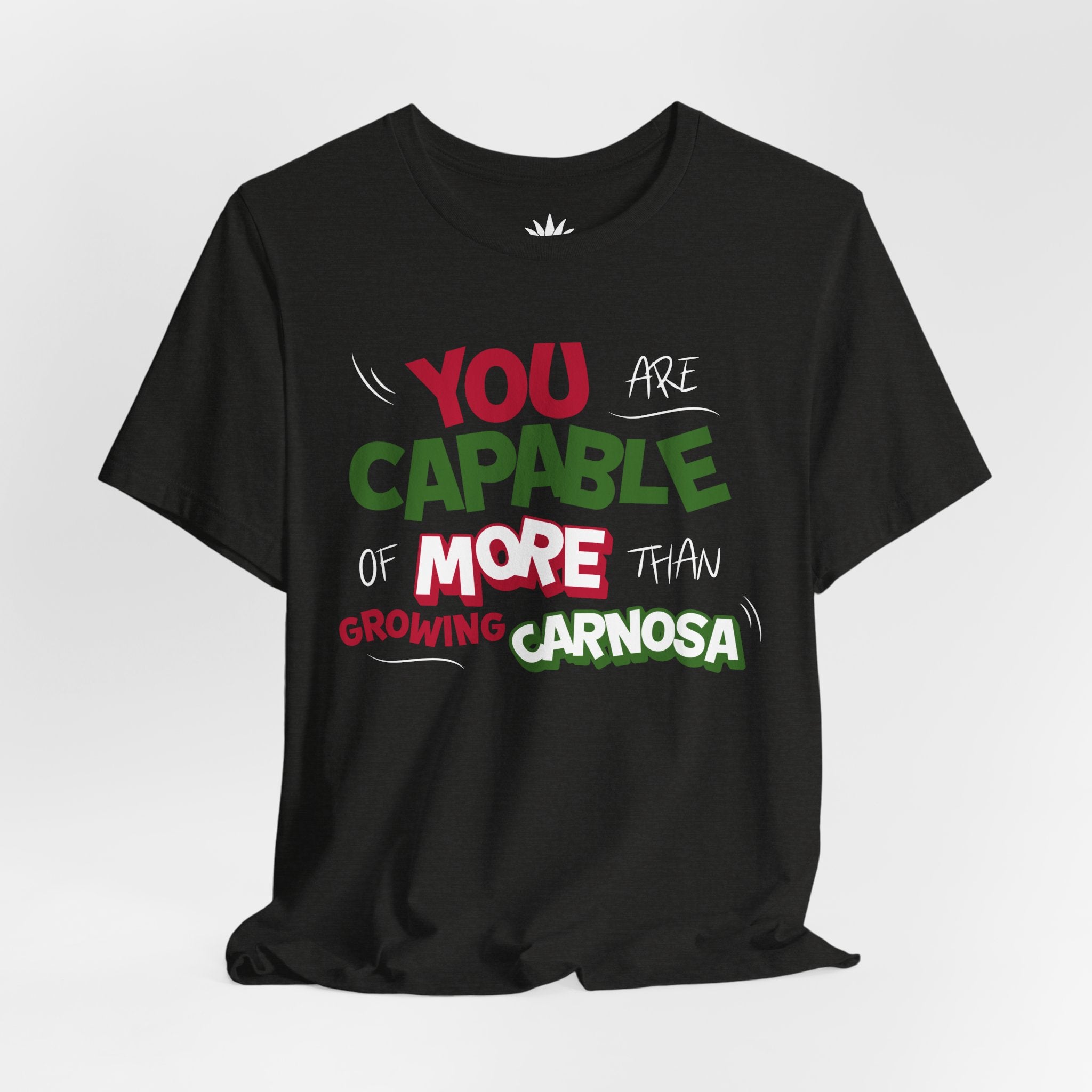 Black t-shirt with bold green, pink, and white “You are capable of more than growing carnosa” lettering for Hoya and plant lovers. Front, hanging.