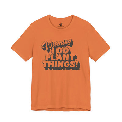 Orange t-shirt with text 'Warning I Do Plant Things!' on a white background