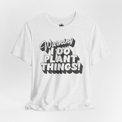 White t-shirt with black text 'Warning I Do Plant Things!' on a light gray background
