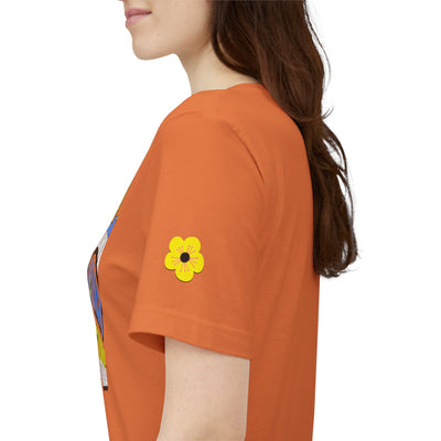 Person wearing an orange t-shirt with a yellow flower design on a white background