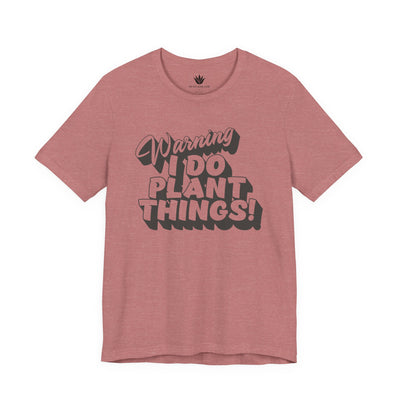 Pink t-shirt with text 'Warning I Do Plant Things!' on a white background