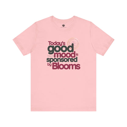 Pink t-shirt with text 'Today's good mood is sponsored by Blooms' on a white background