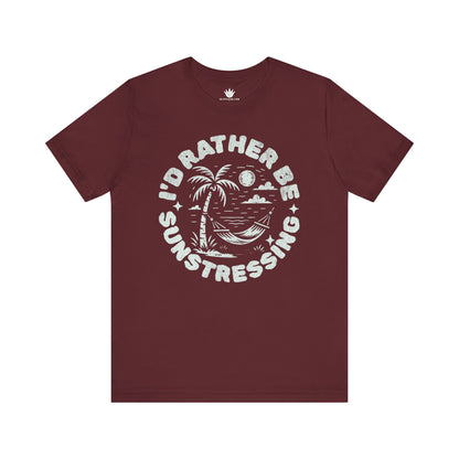Maroon t-shirt with 'I'd Rather Be Sunstressing' graphic on a white background