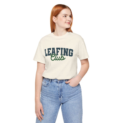 Person wearing a cream t-shirt with 'LEAFING Club' text on a white background