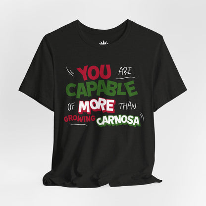 Black t-shirt with bold green, pink, and white “You are capable of more than growing carnosa” lettering for Hoya and plant lovers. Front, hanging.